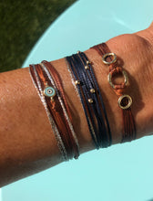 Load image into Gallery viewer, 14k yellow gold featured in rust with sparkly cords; paired with Pleiades (14kG) in navy and Thea (14kG) in rust